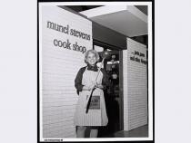 Muriel Stevens in front of her cook shop, circa 1975