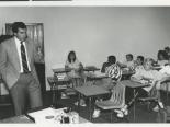 Mark Fine speaking to students in a classroom, 1980s
